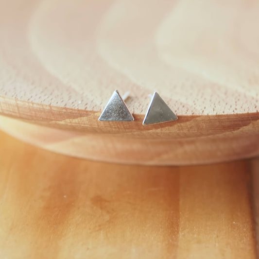 Small silver Stud earrings on a wooden background. Earrings suitable for cartilage piercings and multi piercings and mix and matching. Handmade in Scotland by maram jewellery
