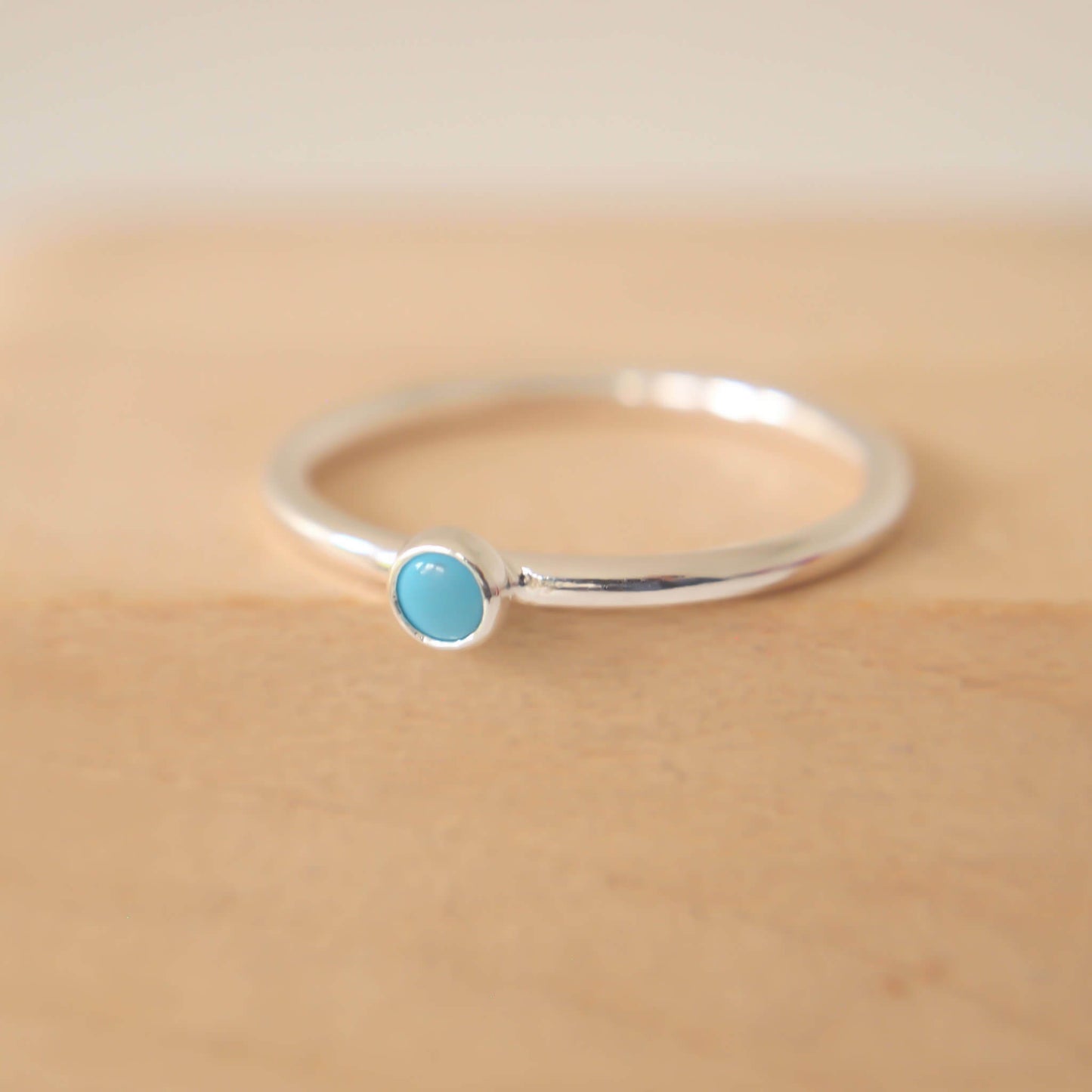 Turquoise and Sterling Silver Ring made from a small 3mm round turquoise gemstone set simply onto a modern band of round wire. Handmade to your ring size by maram jewellery in Scotland