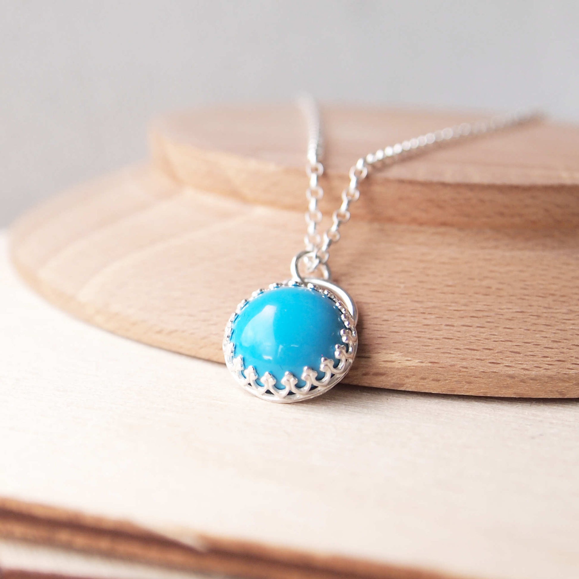 Turquoise gemstone necklace, simple style with a lacy filigree edge to the setting. Made from Sterling Silver and a 10mm sized round cabochon stone and supplied with a chain in a choice of lengths. Handmade by maram jewellery, an independant jeweller and designer working in Edinburgh, Scotland, UK