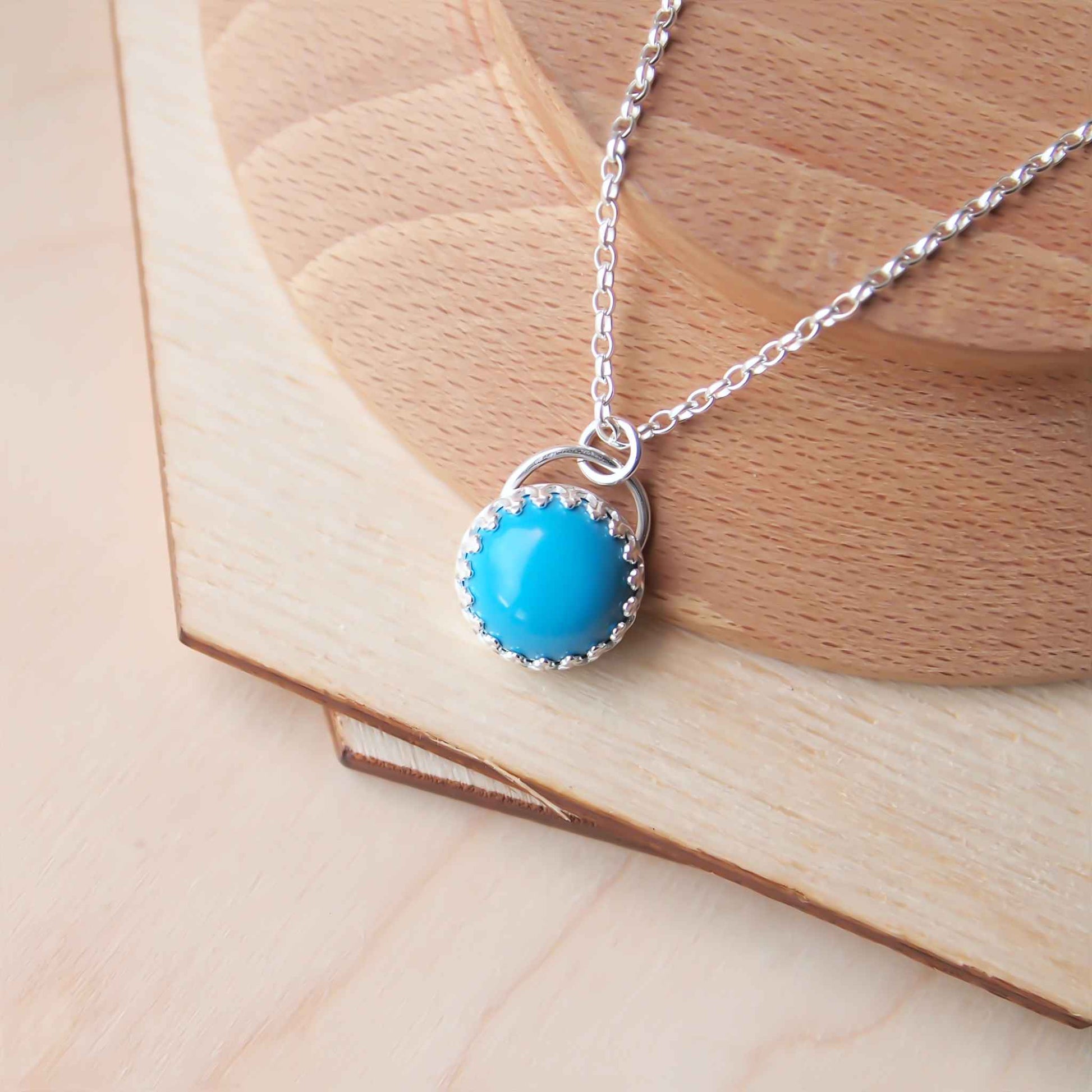Turquoise gemstone necklace, simple style with a lacy filigree edge to the setting. Made from Sterling Silver and a 10mm sized round cabochon stone and supplied with a chain in a choice of lengths.Handmade by maram jewellery, a small artisan jeweller working in Edinburgh Scotland making small batch individual jewellery
