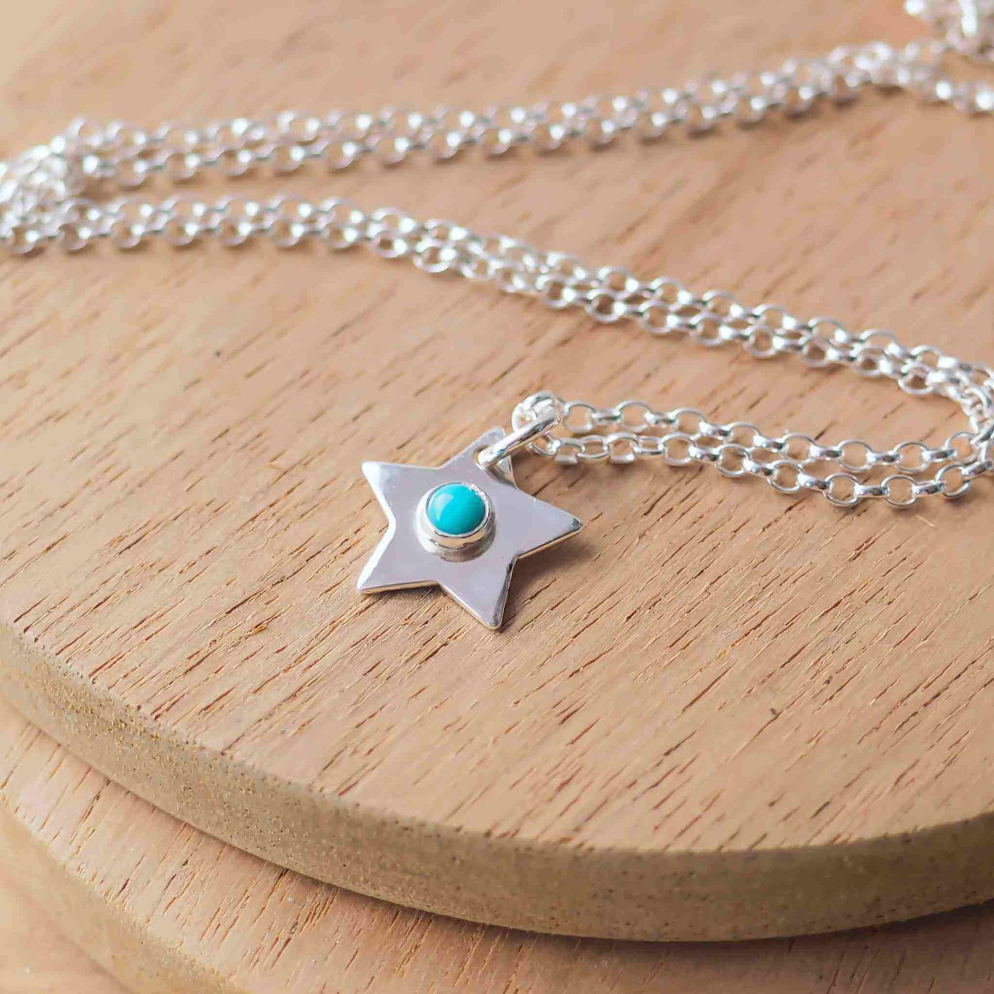 December Birthstone Charm Necklace in the shape of a star with a round 3mm Turquoise cabochon centre. The star measures 12mm in size so is small enough for children as well as adults and is available in a range of other birthstones too. It is Sterling Silver and comes with a choice of chain design and length. Handmade in Scotland by Maram Jewellery