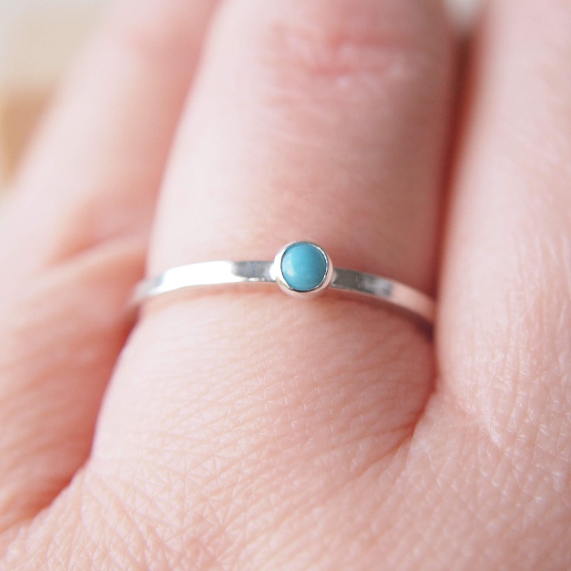 Turquoise and Silver square band ring with a 3mm gemstone pictured on a hand. Handmade by maram jewellery in Edinburgh UK